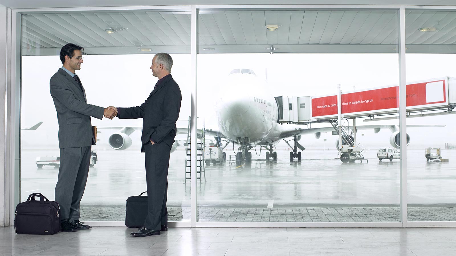 Hombres corporativos dándose la mano en el aeropuerto