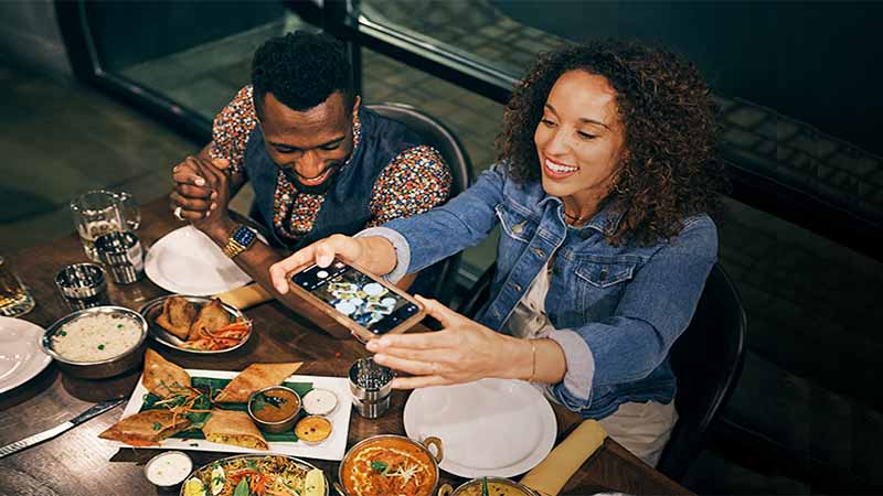 Pareja tomando una foto a su cena