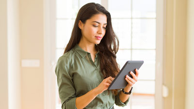 Mujer mirando su celular mientras camina por la ciudad