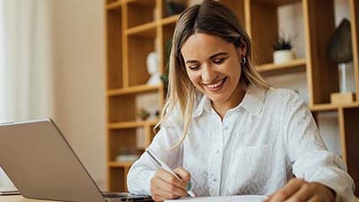 mujer con su pc accediendo al portal de beneficios de Visa