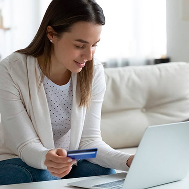 Mujer realizando una compra online con su tarjeta Visa